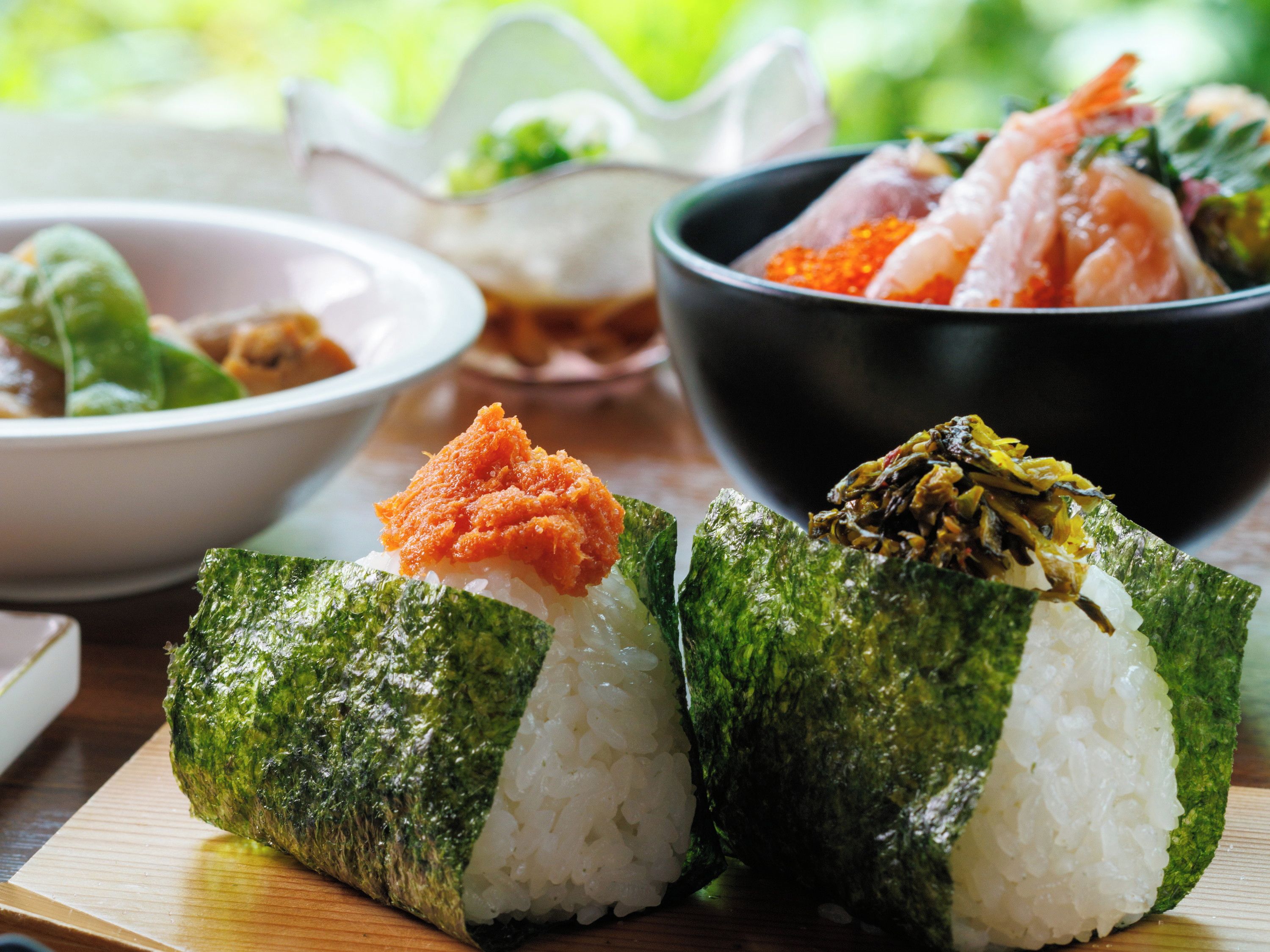 Sushi rolls with rice and seaweed on a wooden table.