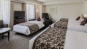 A hotel room with a bed, a desk, a chair, a television, and a window with curtains.