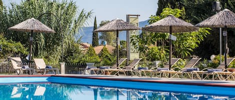 Piscine extérieure, parasols de plage, chaises longues