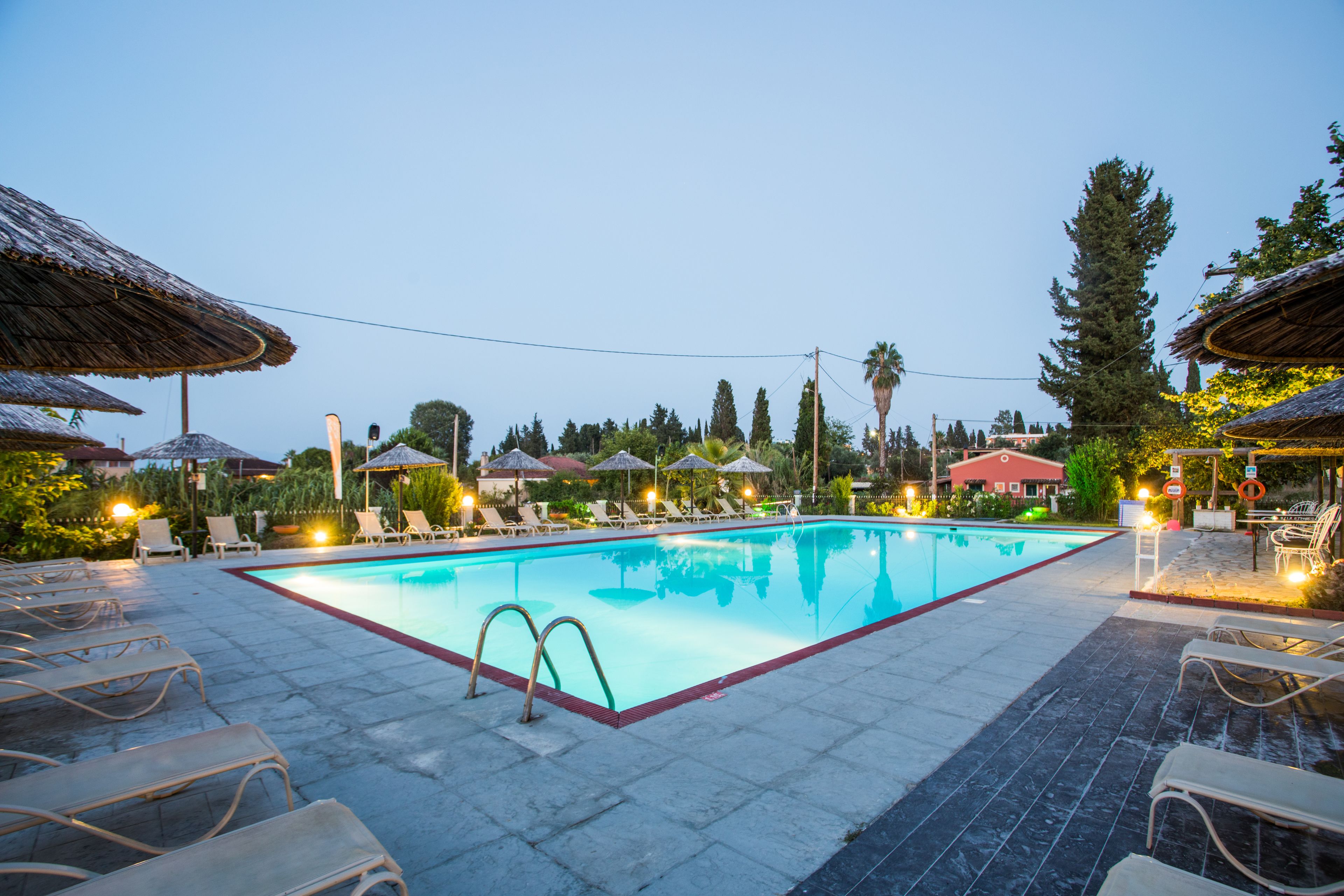Una piscina al aire libre, sombrillas, tumbonas