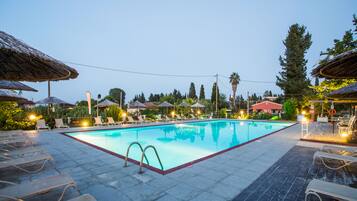 Una piscina al aire libre, sombrillas, tumbonas