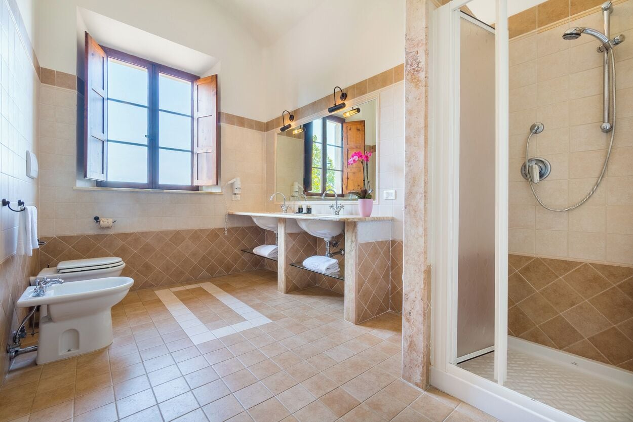 Une salle de bain équipée de toilettes, d’un bidet, d’un lavabo et d’une douche.
