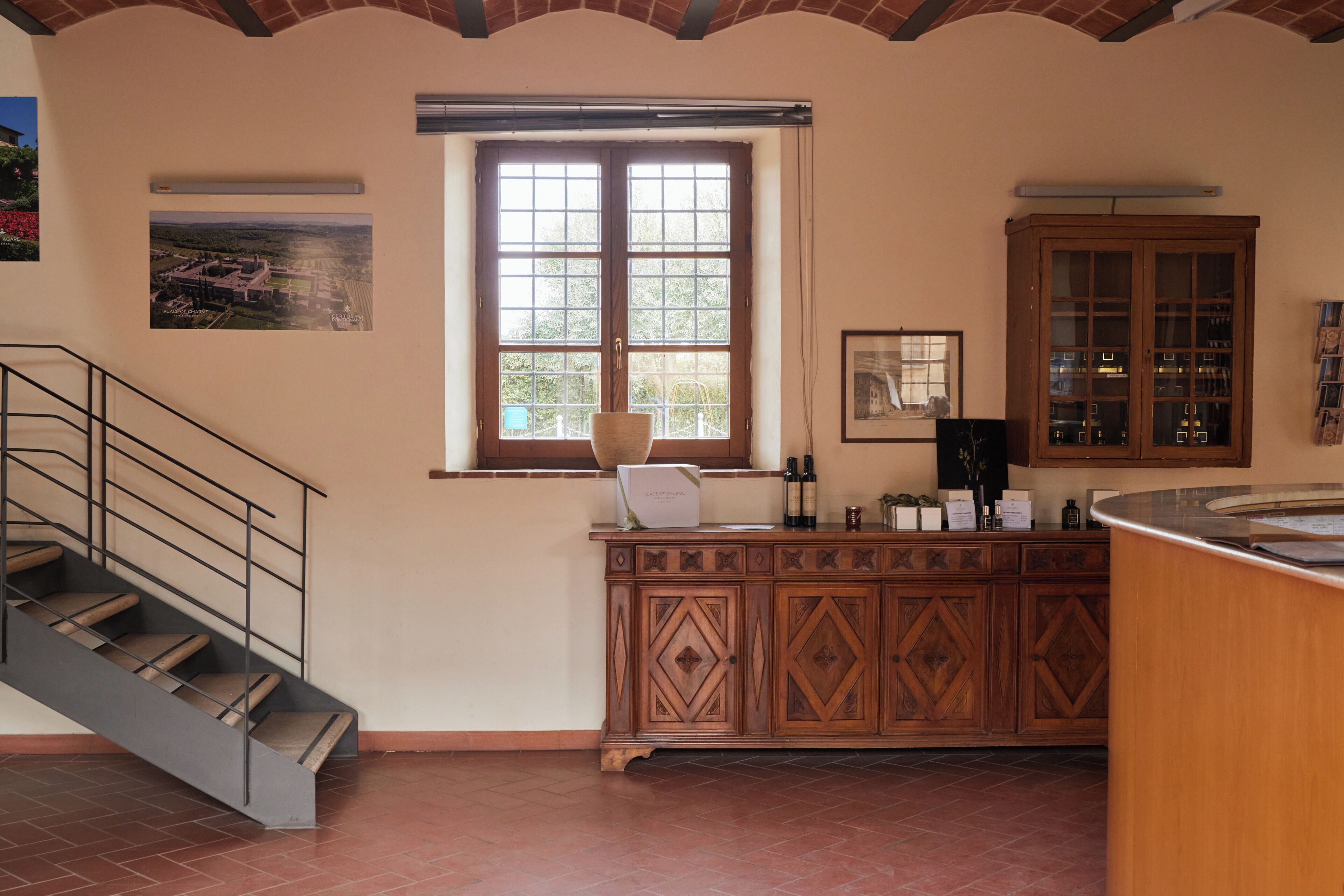 A kitchen with a wooden cabinet, a window, and a staircase.