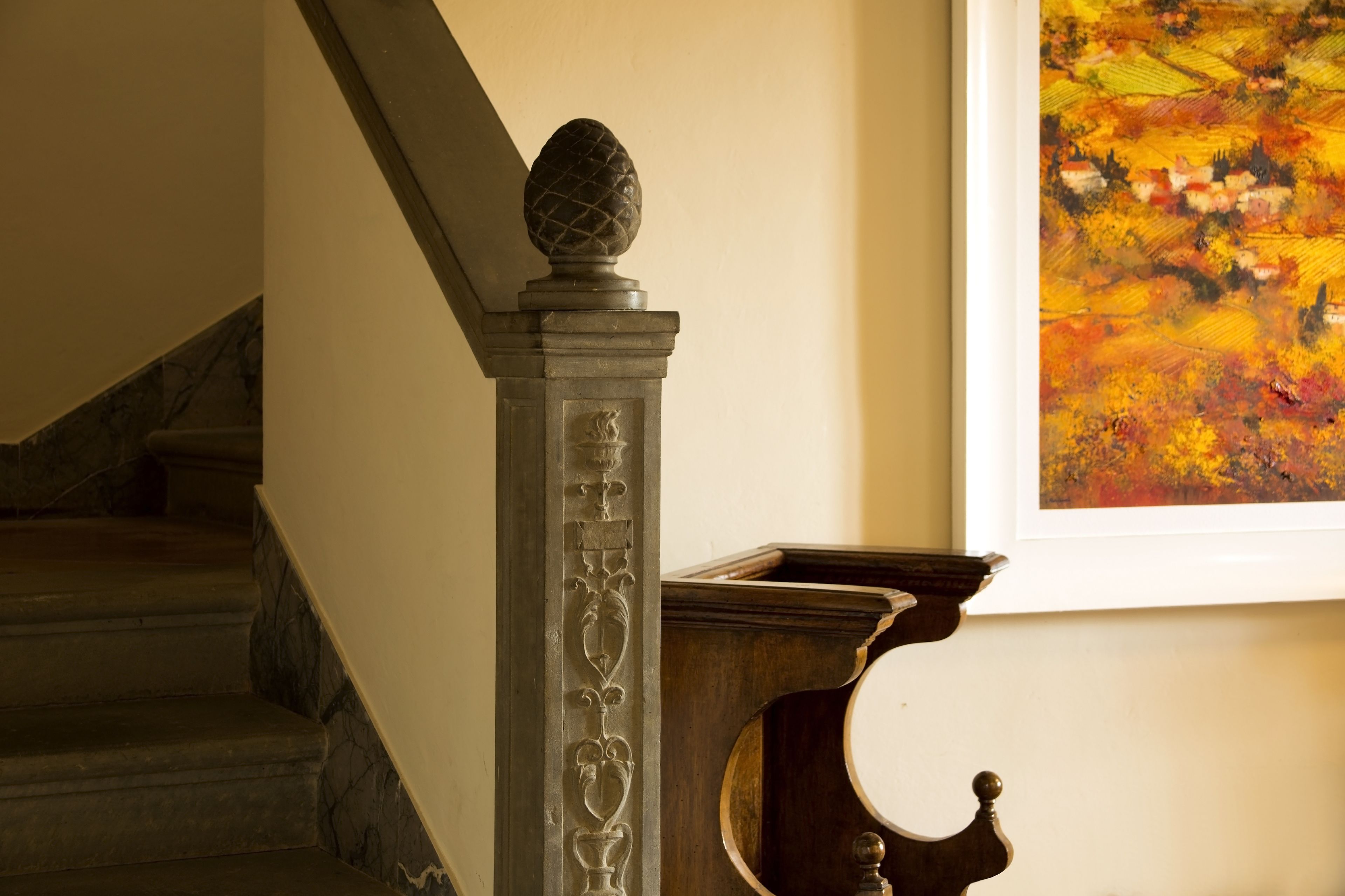 Un escalier orné d’une balustrade décorative et d’un tableau accroché au mur.