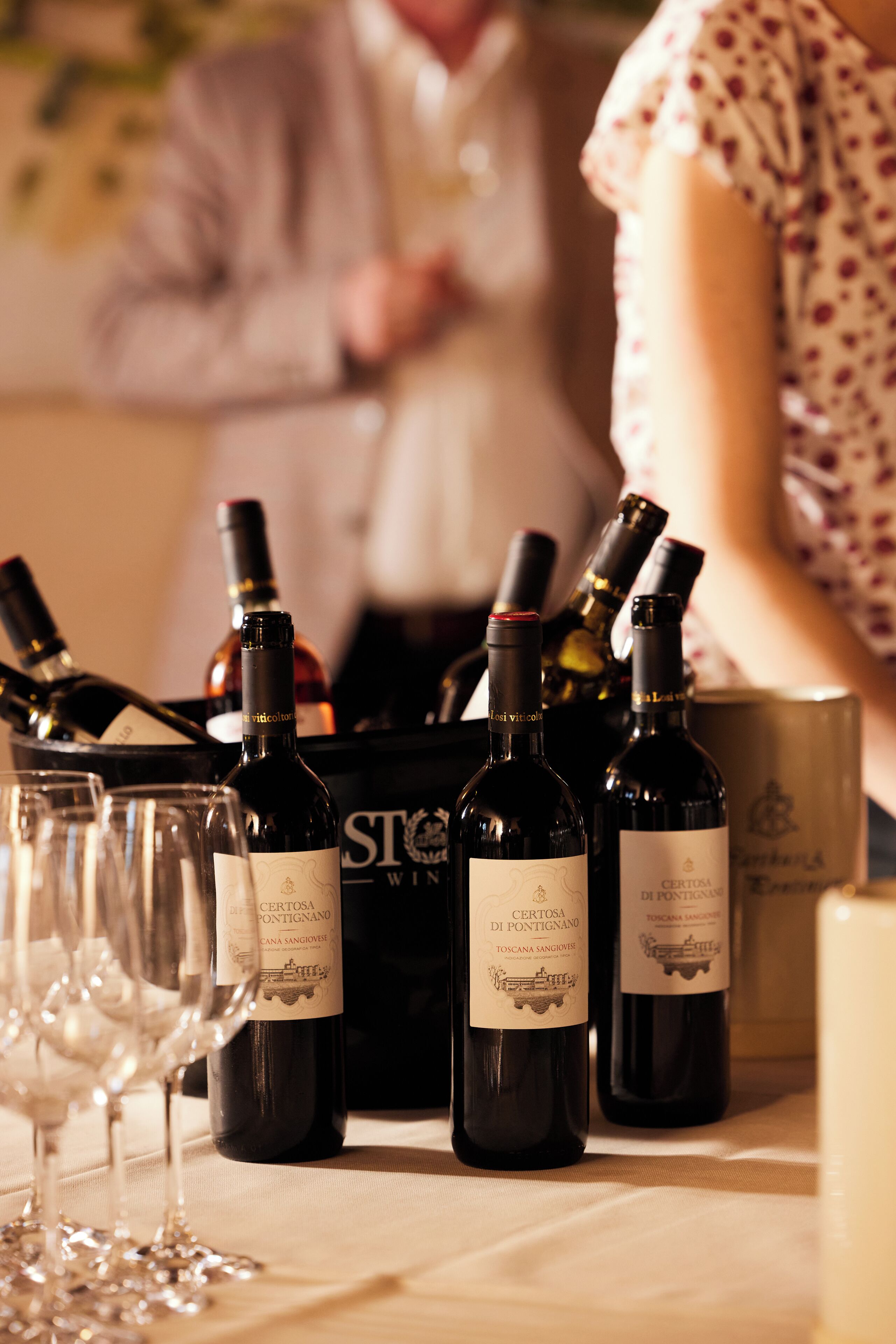 A table with several wine bottles and glasses, likely for a tasting event.