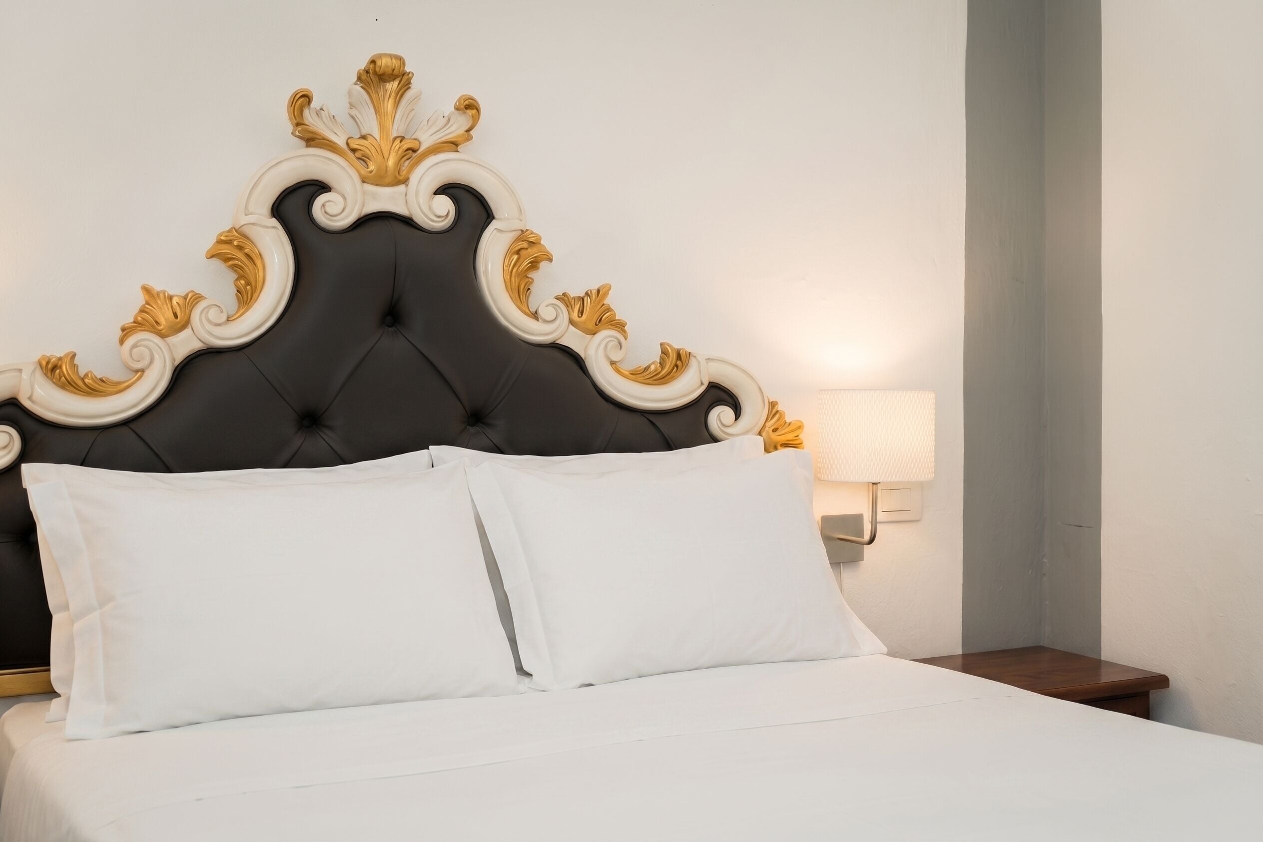 Un letto con una testiera trapuntata e due cuscini.