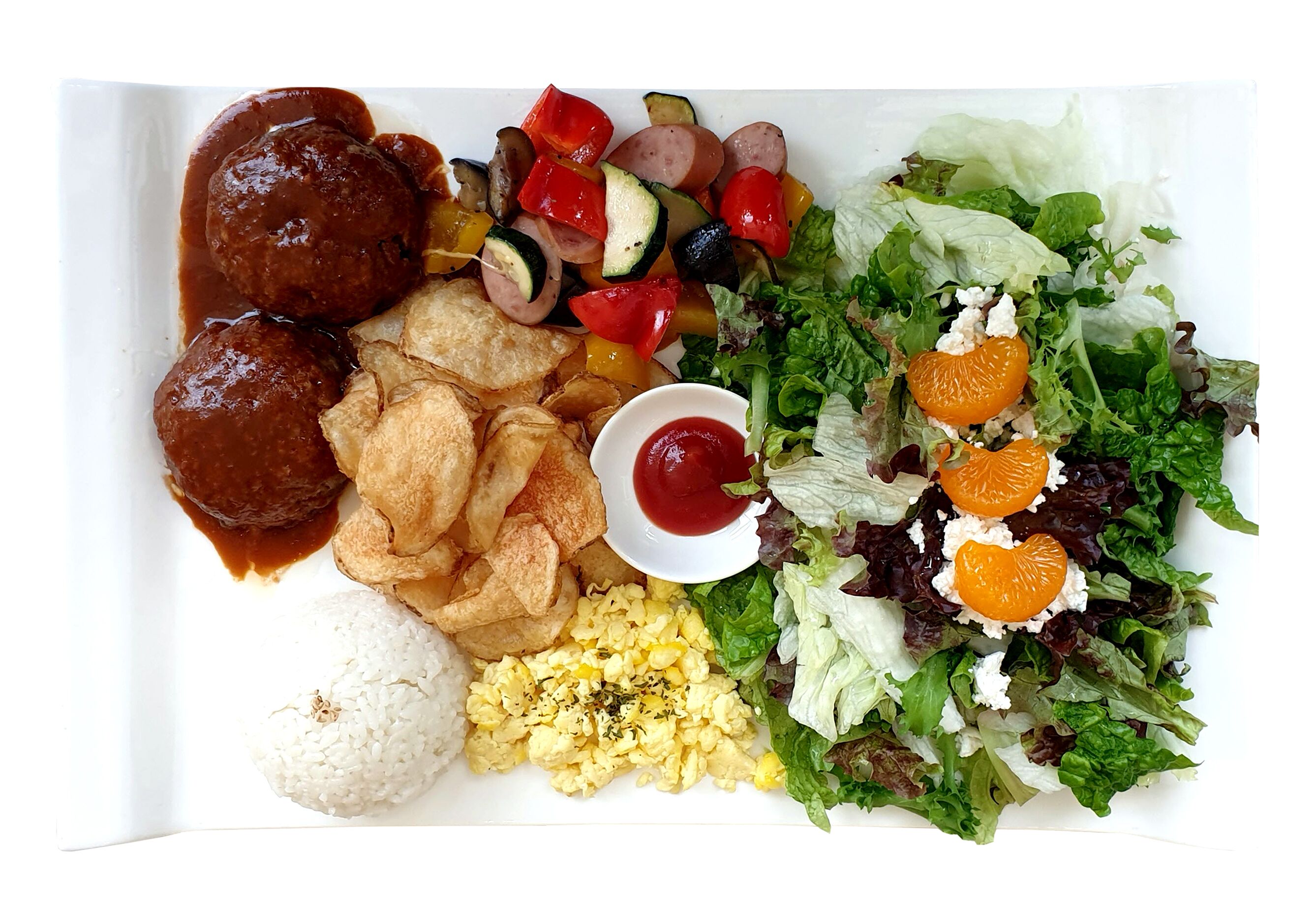 A plate with meatballs, chips, rice, scrambled eggs, and a salad with orange slices.