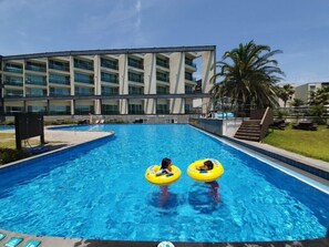Una piscina al aire libre de temporada, sillones reclinables de piscina