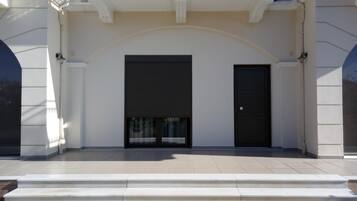 A building with a symmetrical facade, featuring two large black doors and a central arched entrance.