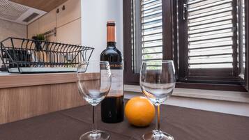 Un comptoir de cuisine avec deux verres à vin, une bouteille de vin et une orange.