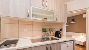 A modern kitchen with a built-in dishwasher, a double sink, and wooden cabinetry. - Apartments Donat Zadar (Zadar)