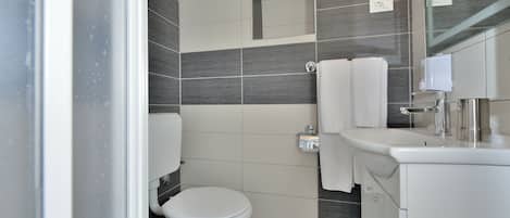 A modern bathroom with a toilet, sink, and mirror.