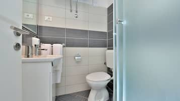 Un baño moderno con inodoro, lavabo y ducha.