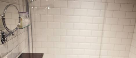 A bathroom with a white bathtub, a sink, and a mirror. The floor is checkered black and white tiles.