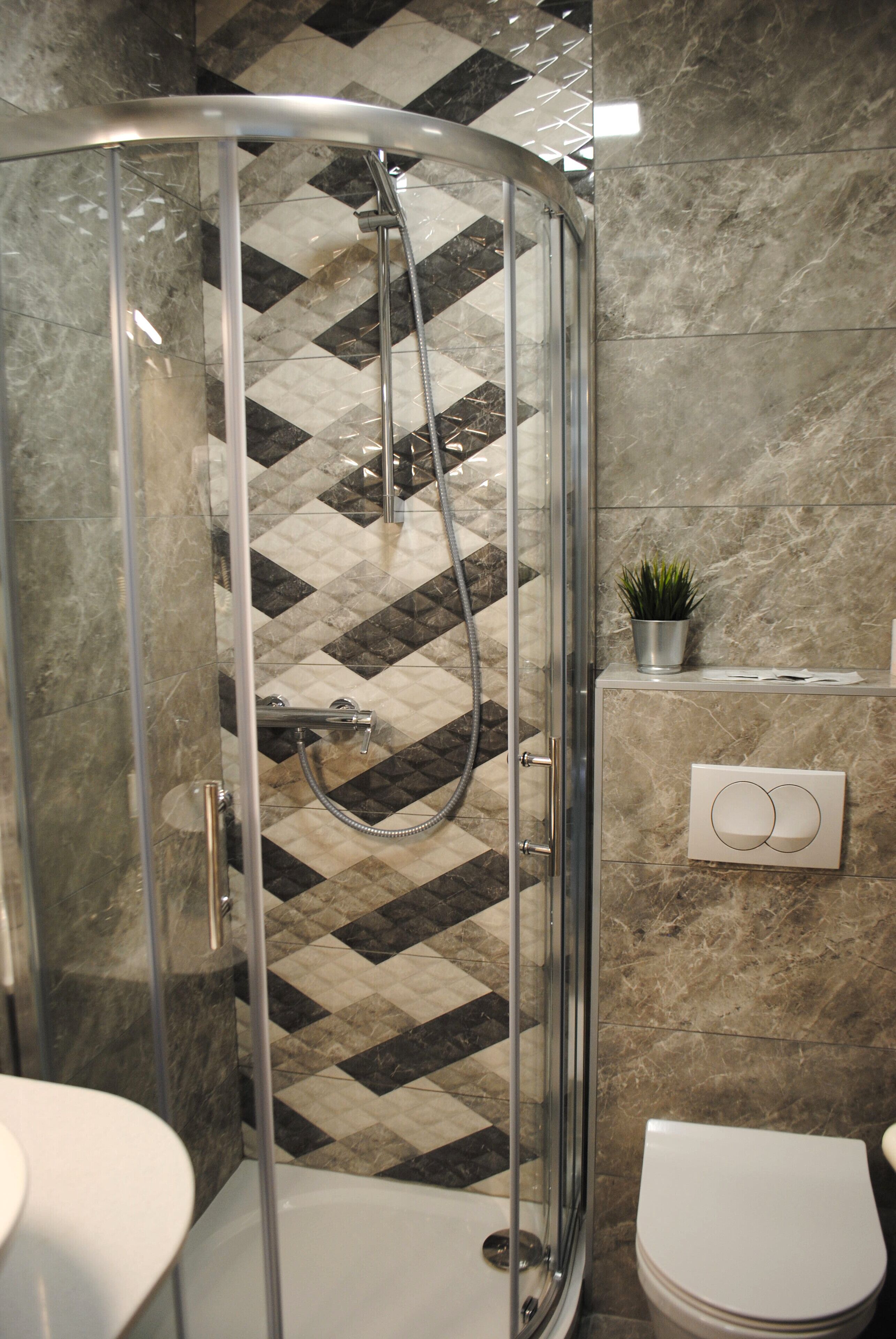 Une salle de bain avec une douche à parois de verre, des toilettes et un lavabo.