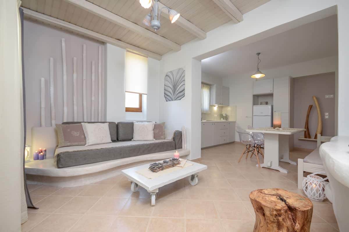A modern living room with a sofa, a coffee table, and a dining area with a table and chairs.