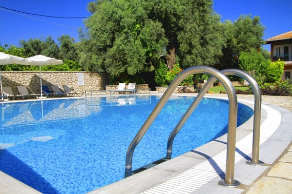 Alberca al aire libre por temporada y sombrillas en la alberca