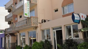 Un hôtel à plusieurs étages doté de balcons, une enseigne indiquant «Hôtel Boavista» et une autre indiquant «Halcyon Air».