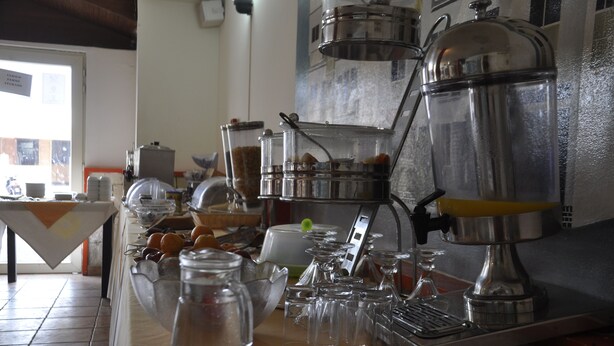 Un espace dédié au café, équipé d’une machine à café, de carafes en verre et d’une variété de tasses et de verres à café.