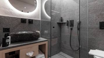 Ein modernes Badezimmer mit einem großen Waschbecken, einer Duschkabine und einer Toilette.