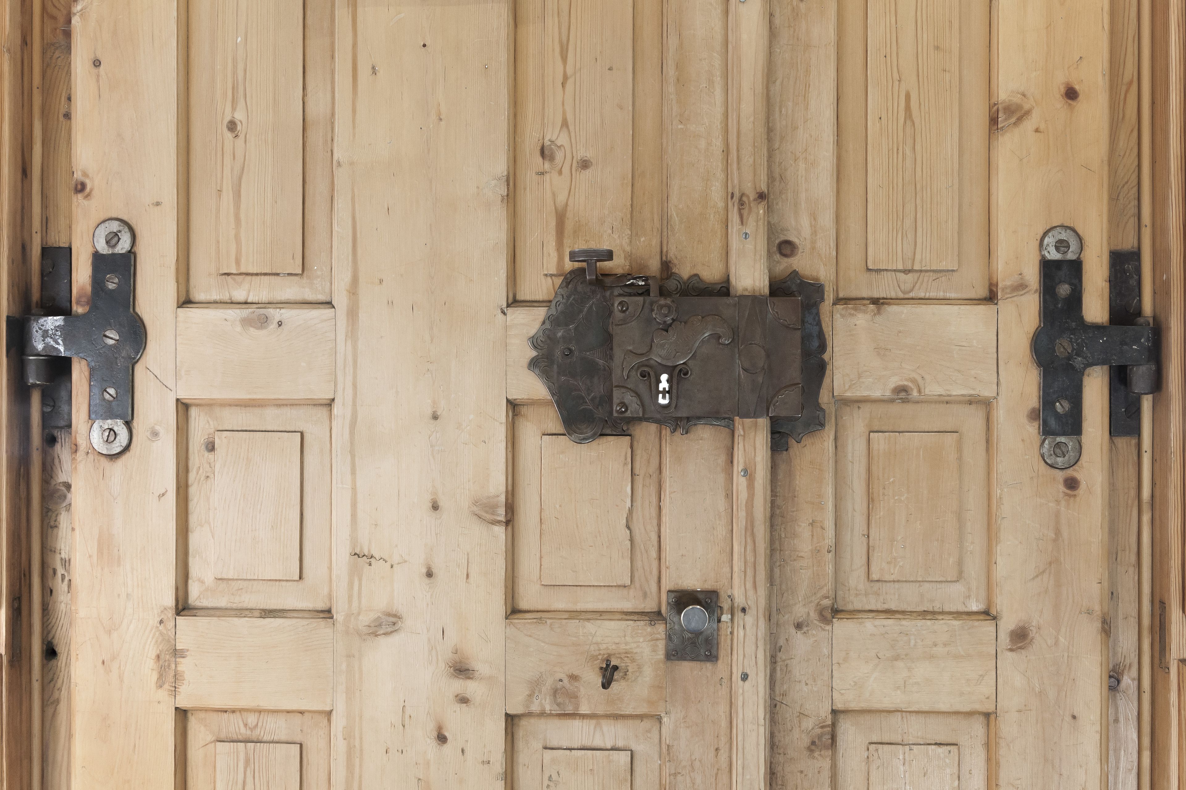 Una puerta de madera con un cerrojo metálico y una cerradura.