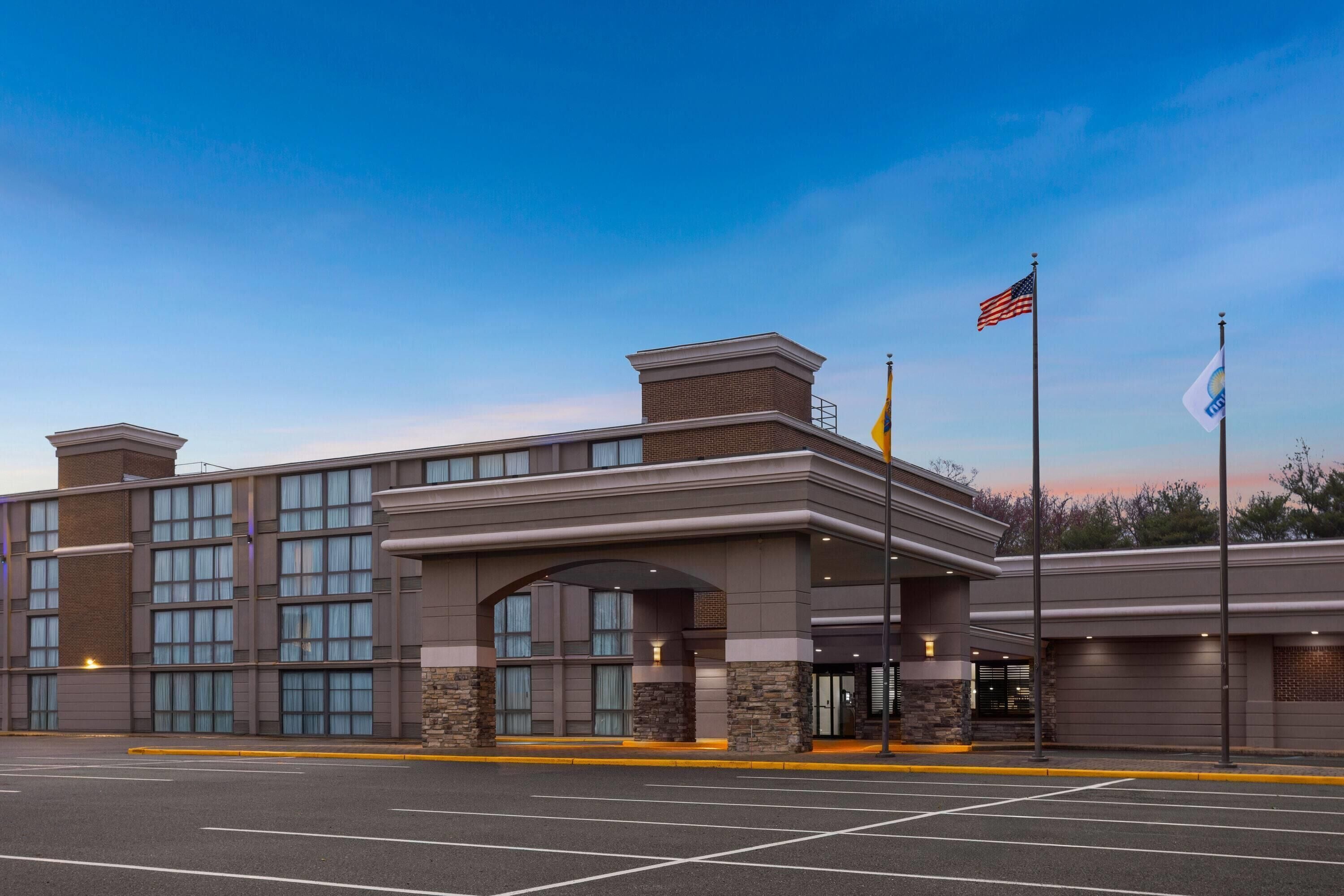 A hotel with a brick facade, large windows, and a covered entrance.