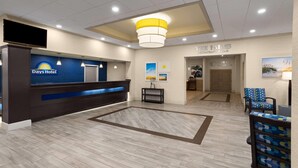 A hotel lobby with a reception desk, a restaurant, and a bar. - Days Hotel by Wyndham Toms River Jersey Shore (Toms River)