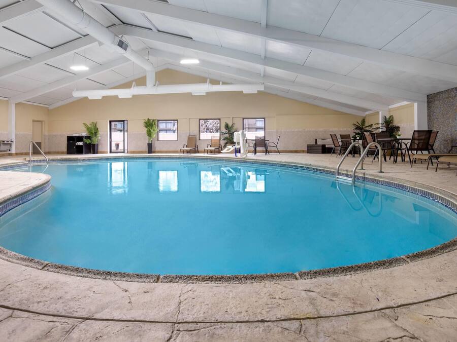 Une piscine intérieure à l’eau claire, entourée de carreaux de pierre et équipée d’une échelle.