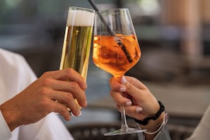 Two people holding glasses of different beverages.