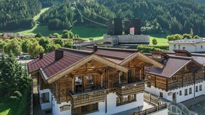 A traditional wooden chalet with a balcony, set against a mountainous backdrop. - Hotel Gasthof Brücke (Mayrhofen)