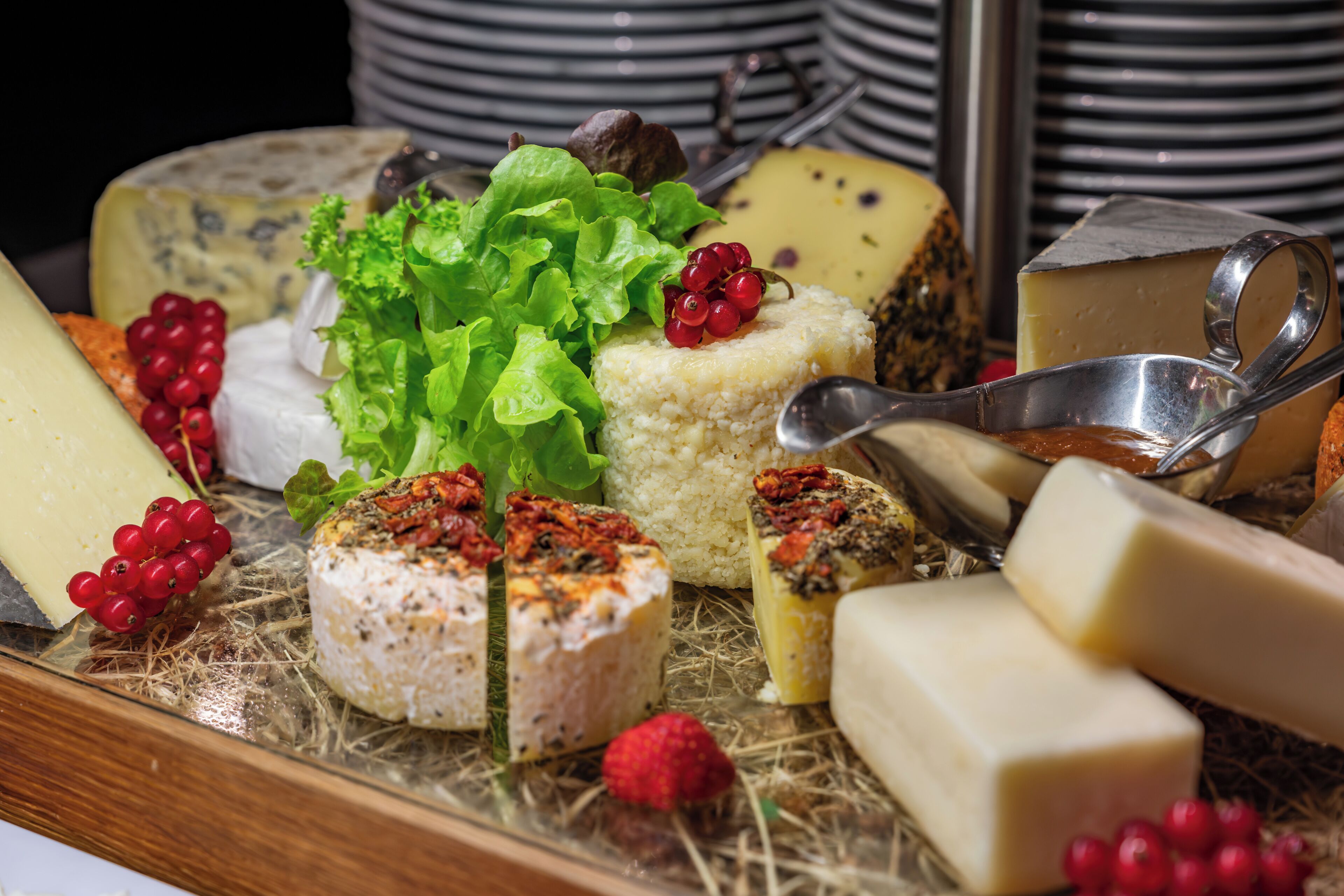 A variety of cheeses and fruits on a tray.
