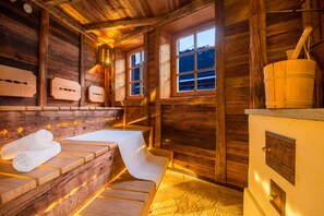 A wooden cabin interior with a sauna, wooden benches, and a wooden stove. - Hotel Gasthof Brücke (Mayrhofen)