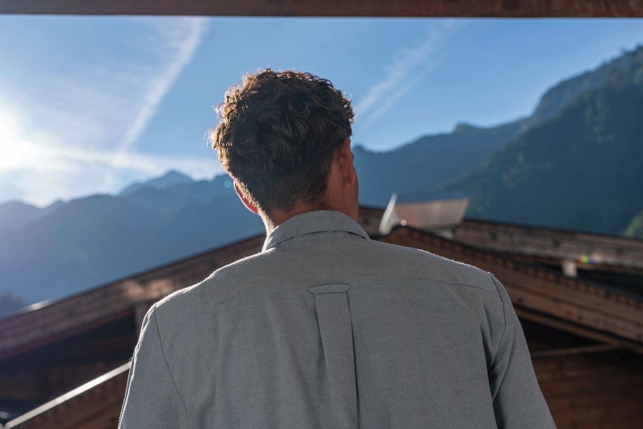 A person standing with a mountainous landscape in the background.