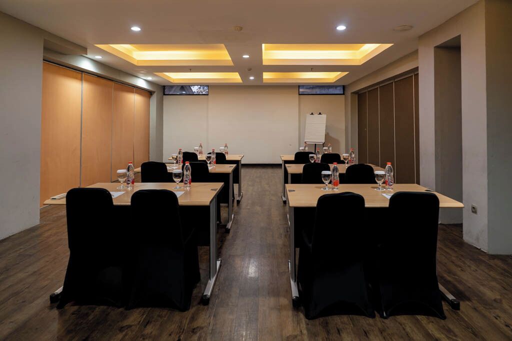 A conference room with long tables, chairs, and a whiteboard.