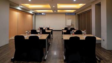 A conference room with long tables, chairs, and a whiteboard.
