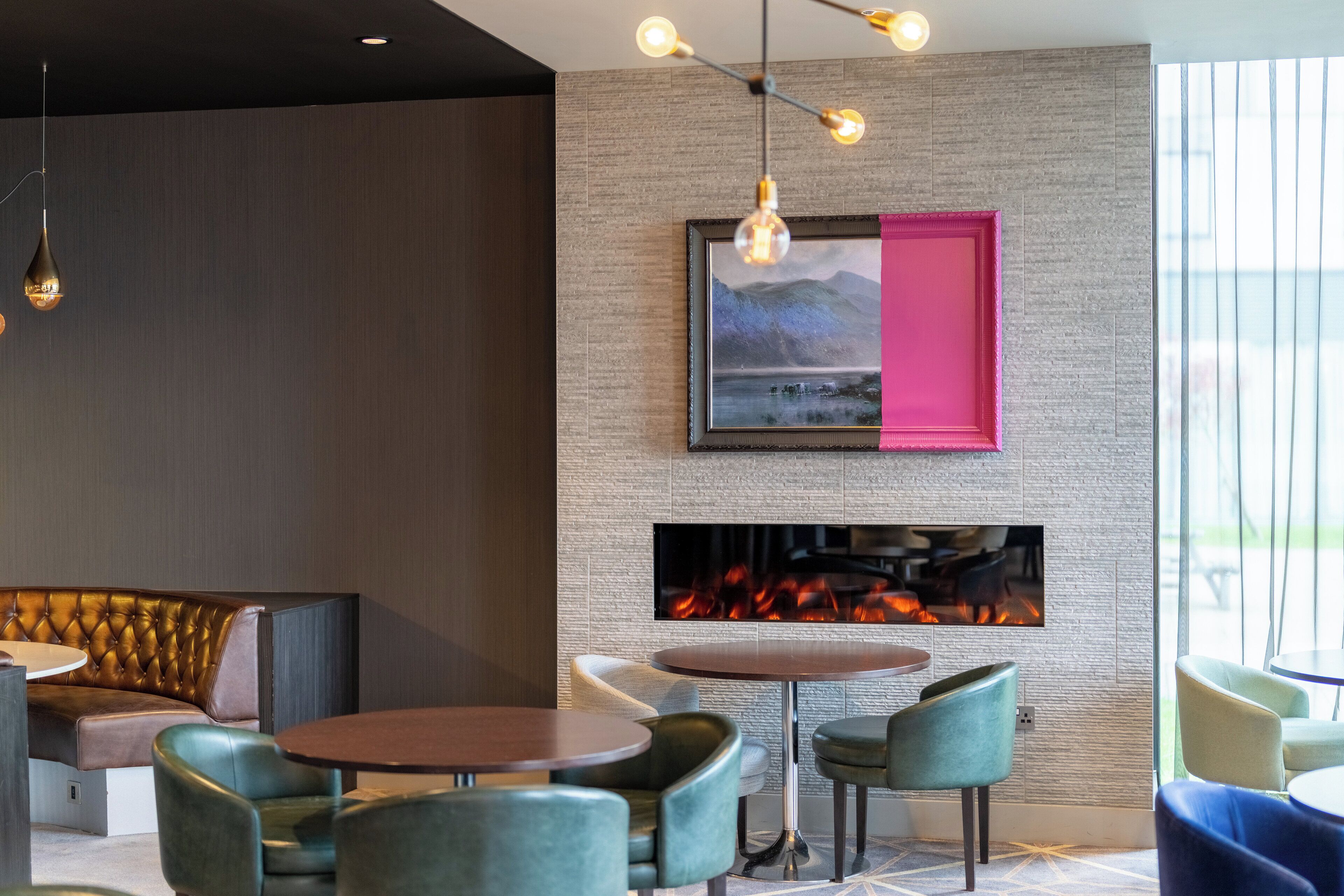 A modern interior with a fireplace, seating area, and pendant lighting.