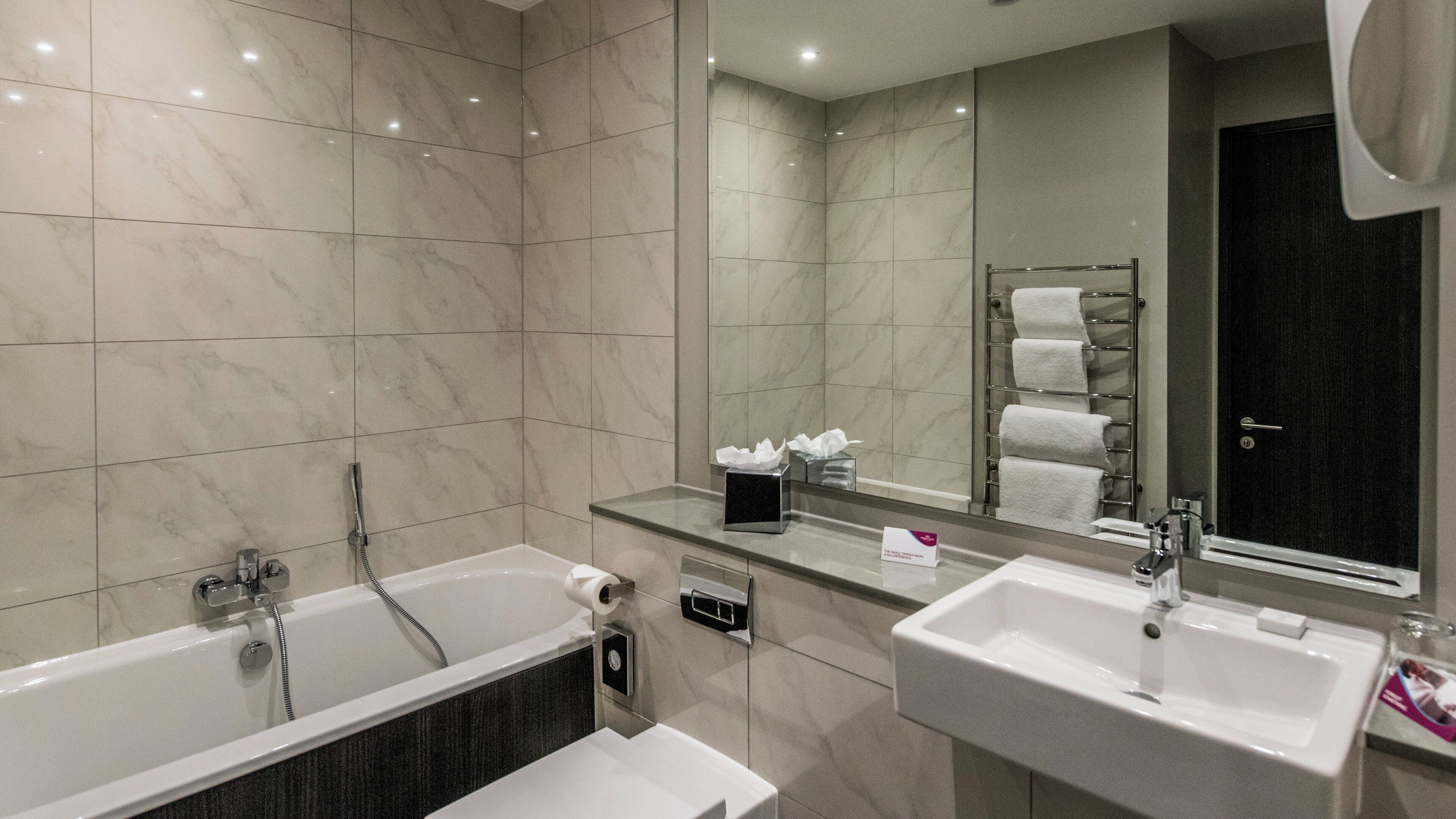 Une salle de bain moderne avec une baignoire, un lavabo et un porte-serviettes.