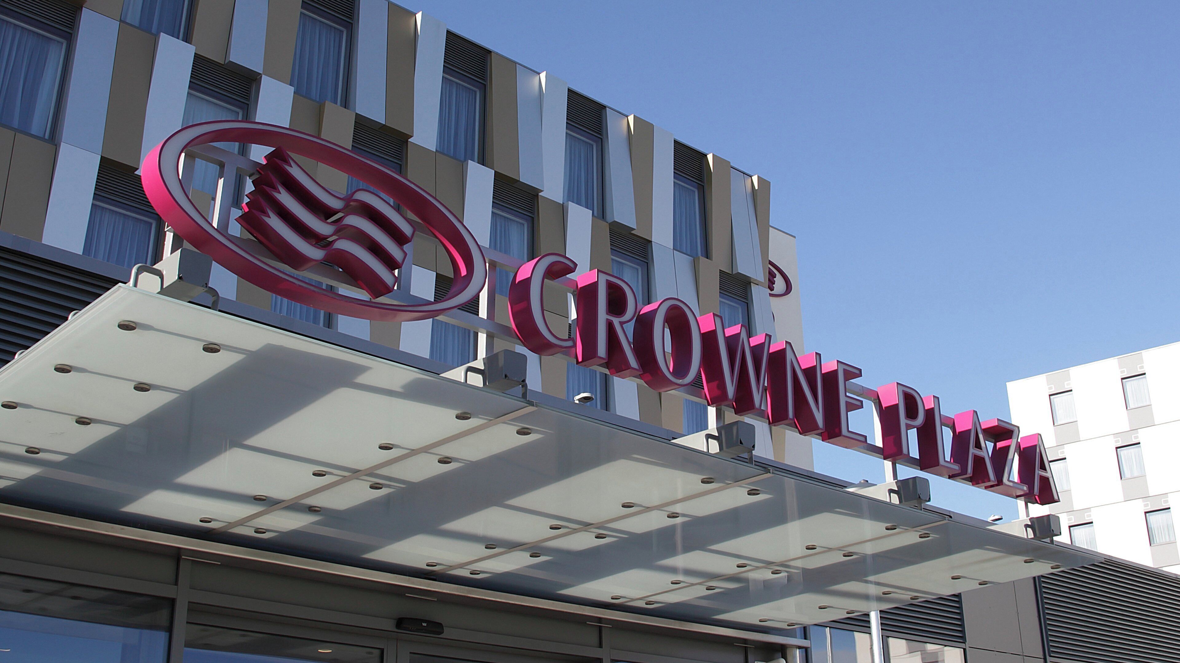 A hotel sign with a distinctive logo and the name 'CROWNE PLAZA' in large letters.