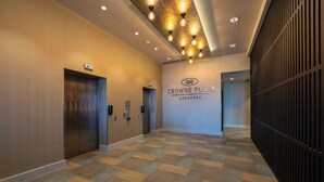 A hallway with a checkered floor, two elevators, and a wall with the text "CROWNE PLAZA ABERDEEN". - Crowne Plaza Aberdeen Airport by IHG (Aberdeen)