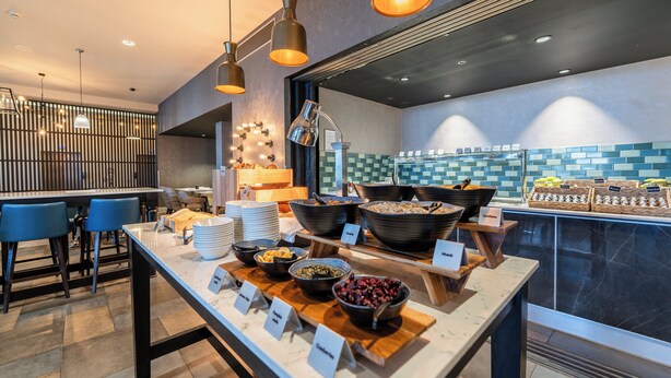 A breakfast buffet with various food items and a seating area with blue chairs. - Crowne Plaza Aberdeen Airport by IHG (Aberdeen)