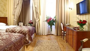 A hotel room with two beds, a desk, a chair, a TV, and a window with curtains. - Moskva (Belgrade)
