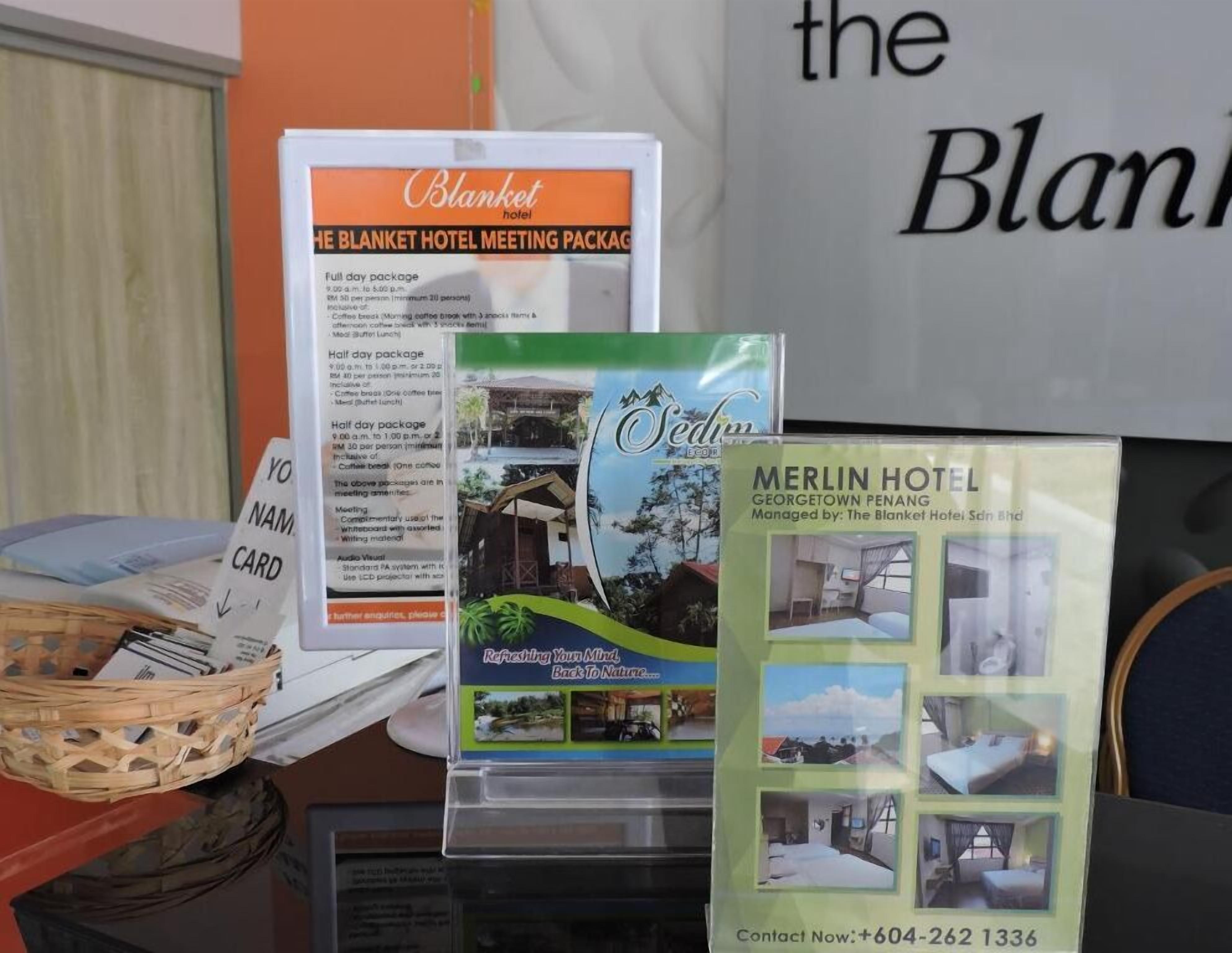 A brochure for the Merlin Hotel in Georgetown Penang, managed by The Blanket Hotel Sdn Bhd, with a contact number +604-262 1336.