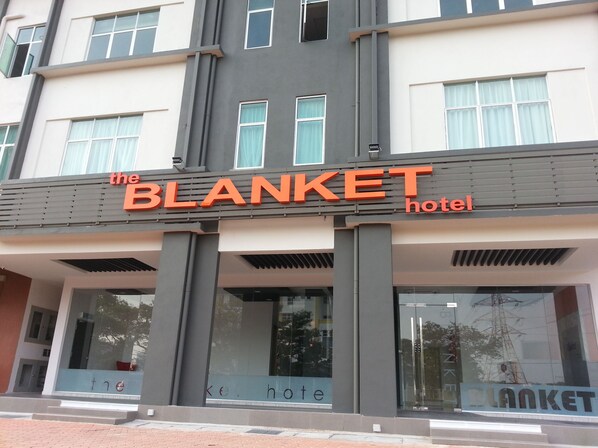 The exterior of The Blanket Hotel with a modern facade, large windows, and a prominent sign. - The Blanket Hotel (Seberang Jaya)