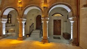 A corridor with arched ceilings, stone columns, and wooden doors. - Maccan Cave Hotel (Nevsehir)