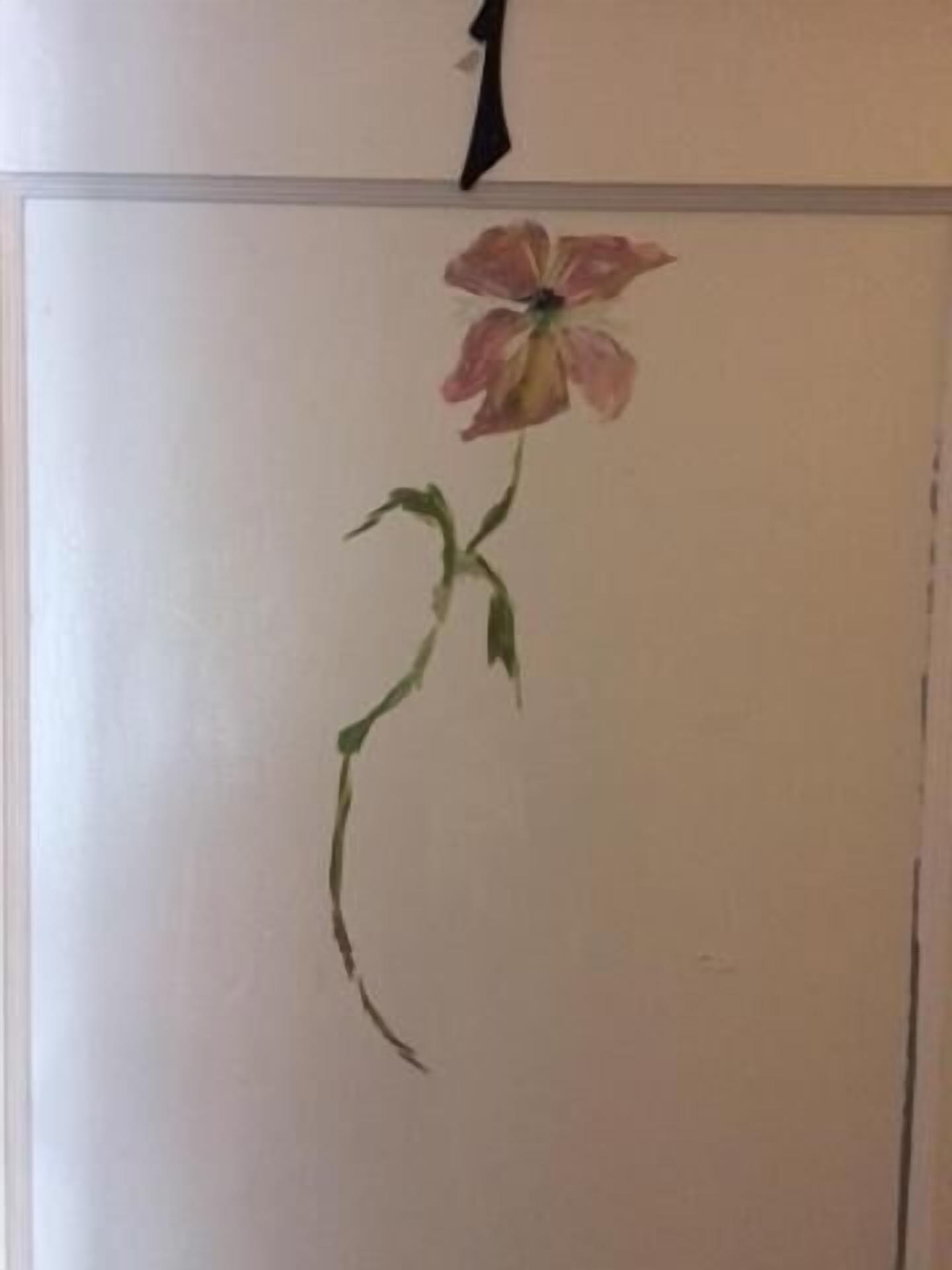 En væg med et enkelt blomsterportræt.
