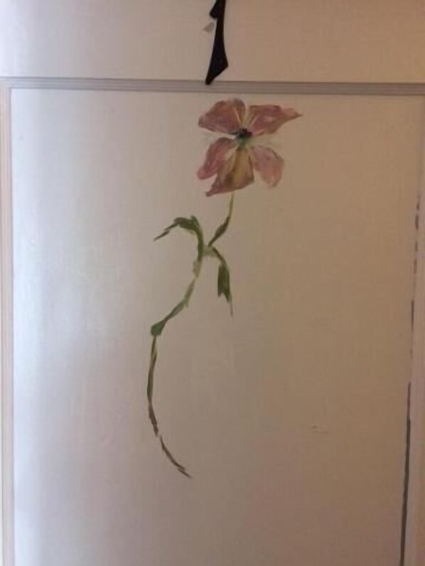 A wall with a single flower painting.