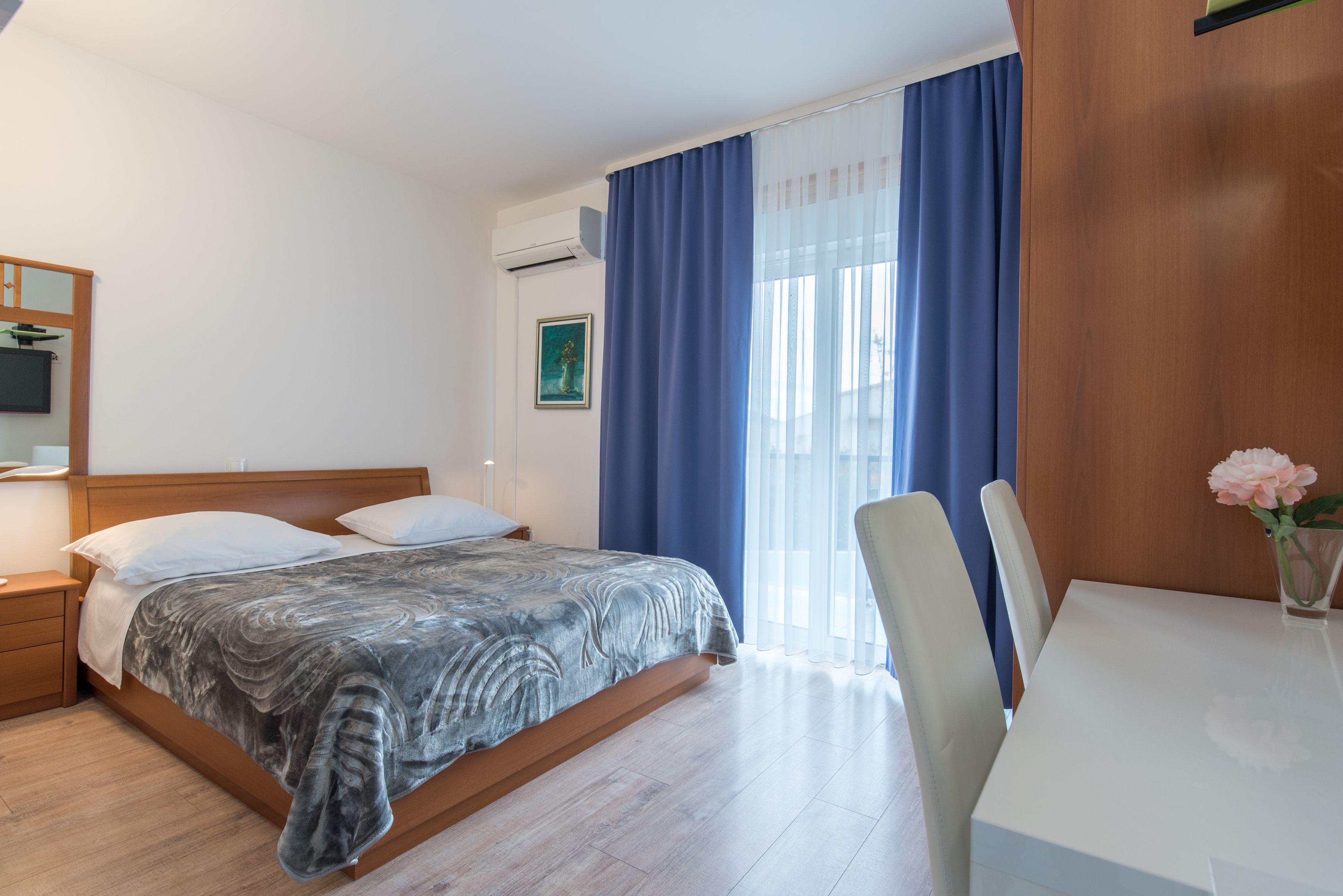 Ein Schlafzimmer mit einem Bett, einem Nachttisch und einem Fenster mit Vorhängen.