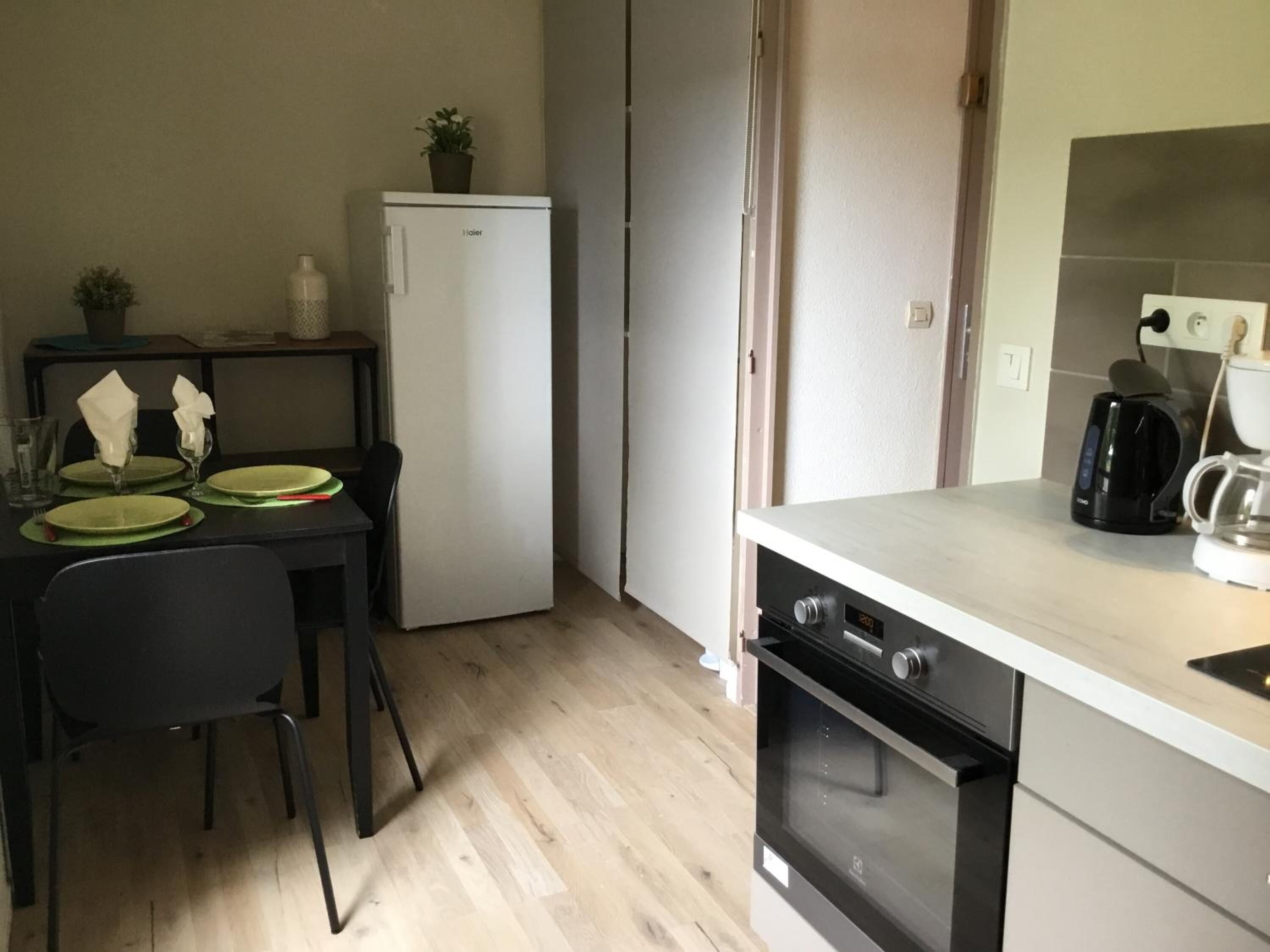 Una cocina compacta equipada con refrigerador, cafetera y microondas.
