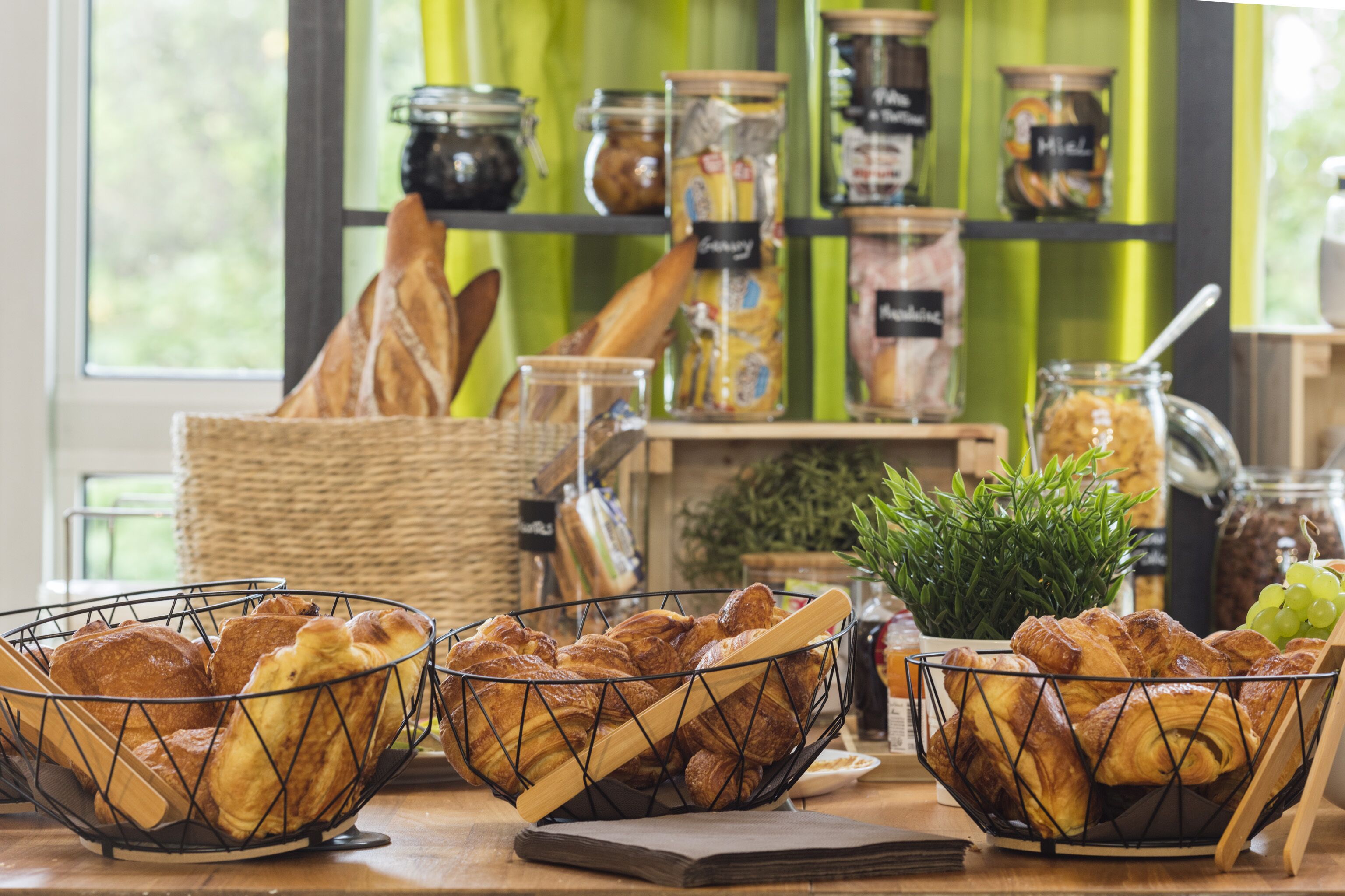 A bakery display with various baked goods and jars of preserves.