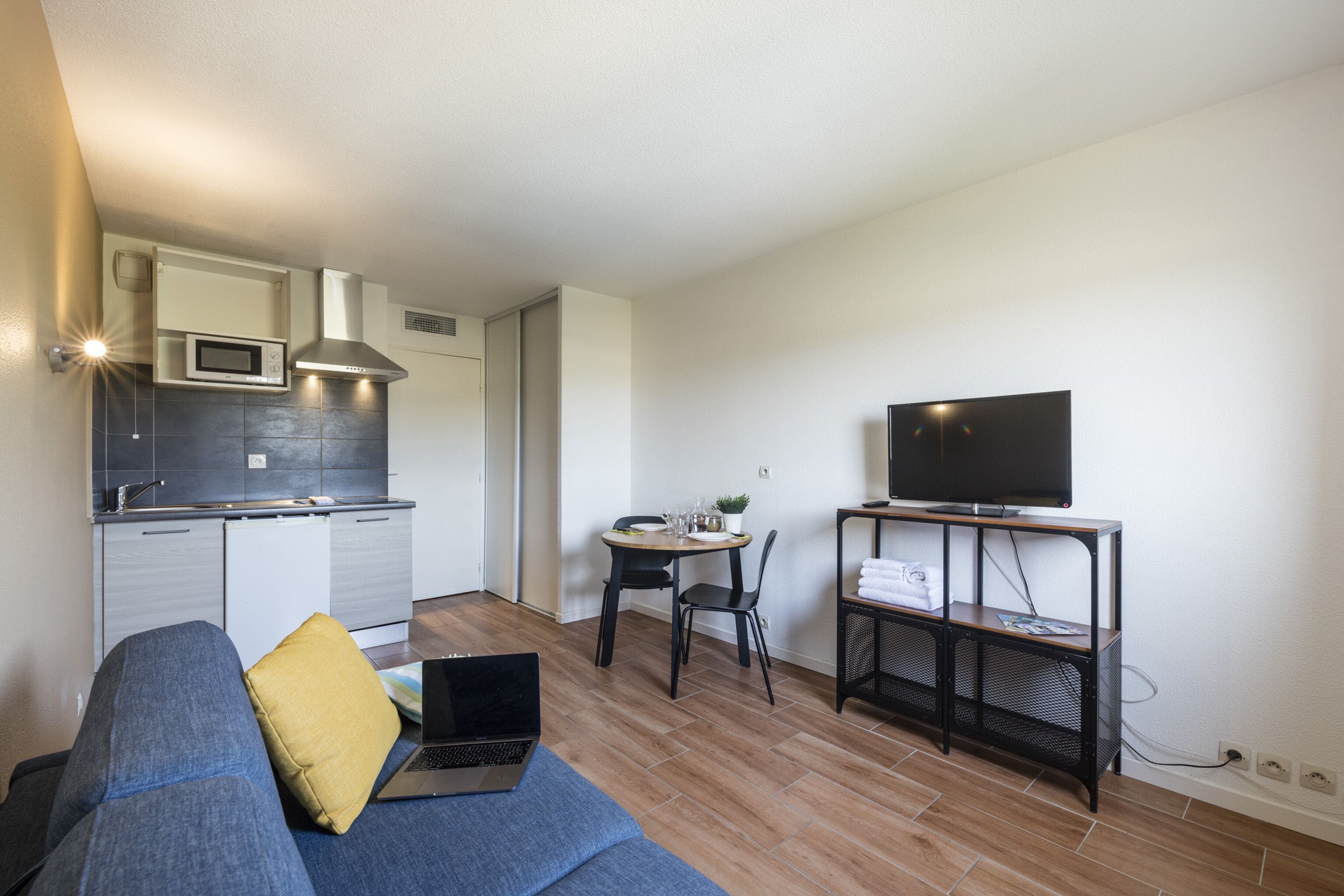 A modern living room with a sofa, a coffee table, and a TV stand.